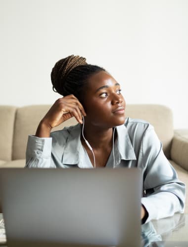 Person thinking while working at a laptop